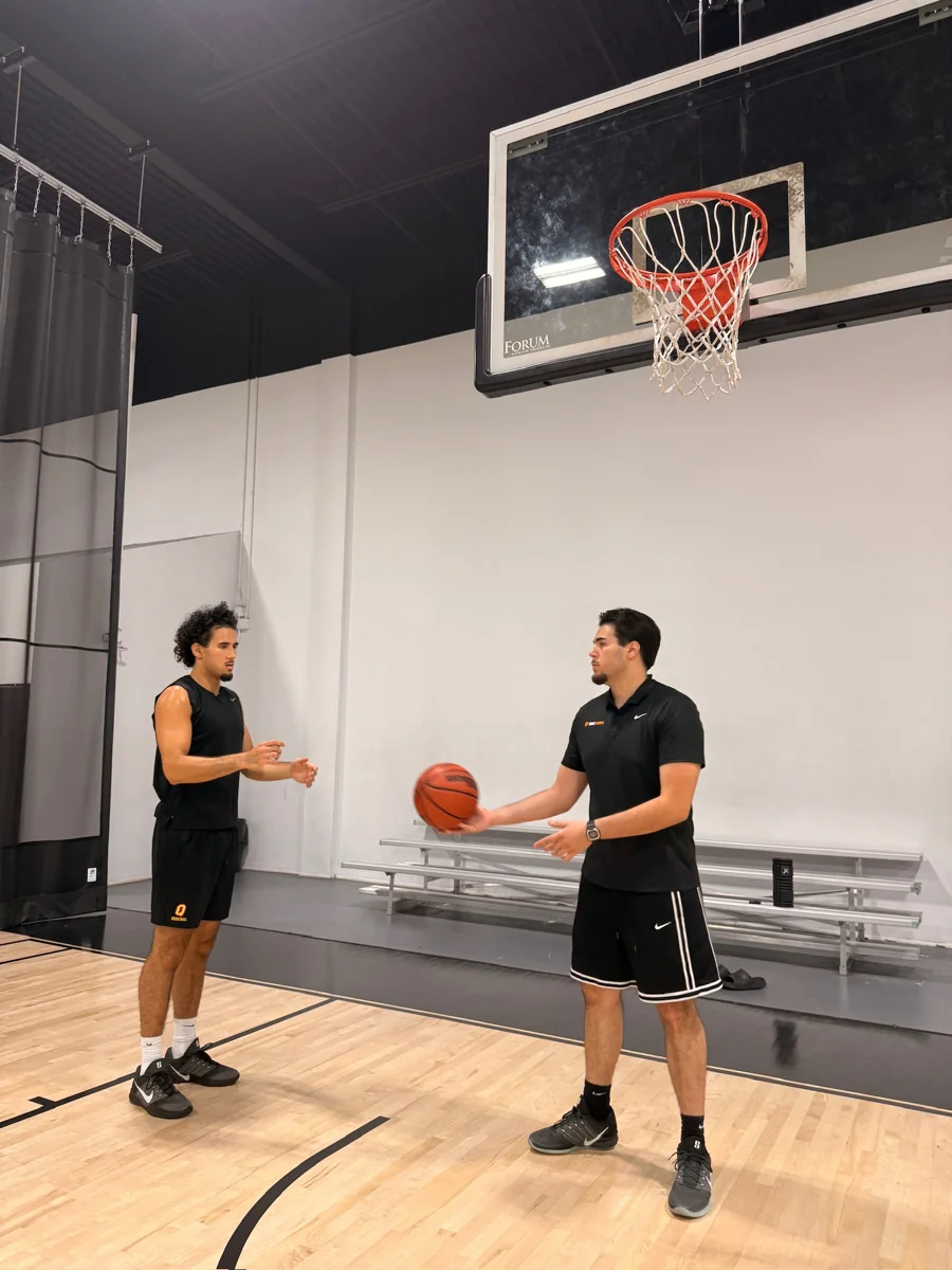 Mert Uraz discussing a drill with a player on an indoor court