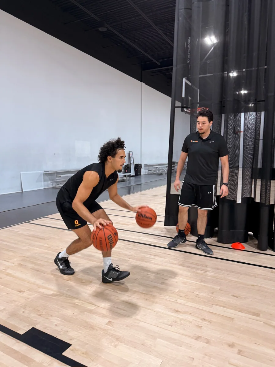 Mert Uraz observing a player practising two-ball handling indoors