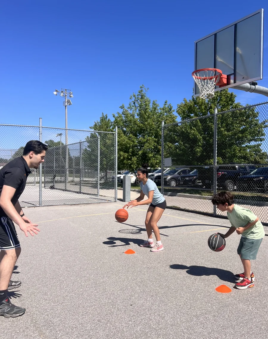 Mert Uraz coaching two players through an outdoor ball-handling drill