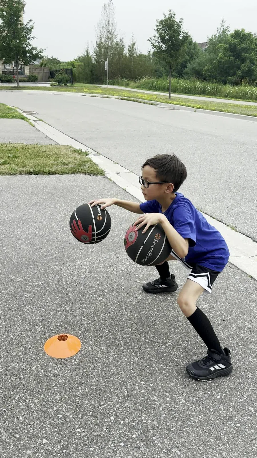 A young player practising two-ball handling outdoors
